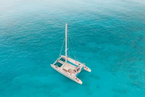 Catamaran sailing in crystal-clear turquoise waters, perfect for relaxed family cruising in Greece.